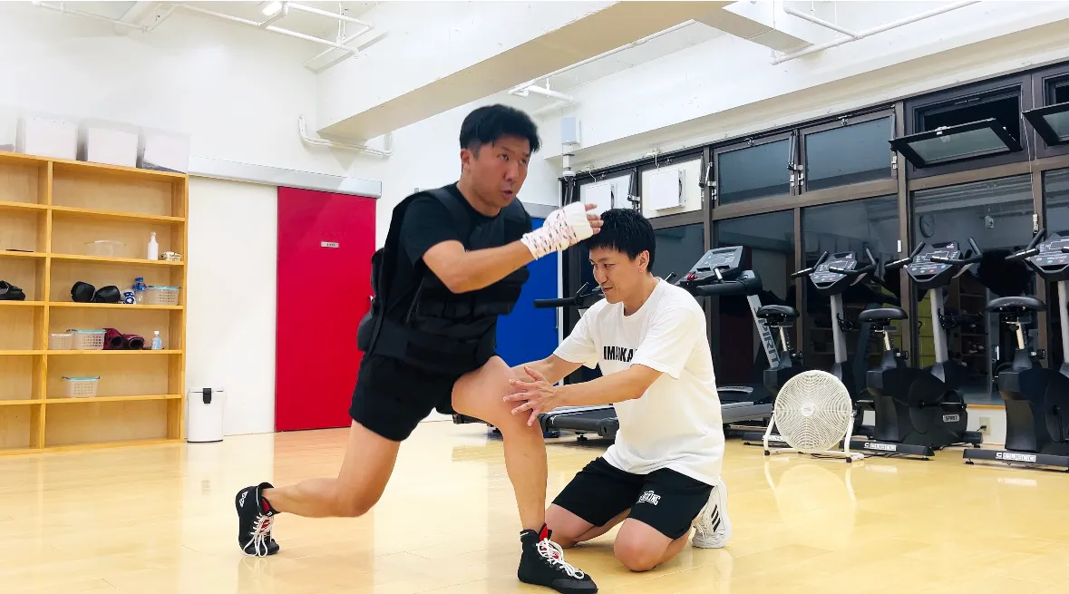 経験豊富なトレーナーが初心者会員に基本フォームを丁寧に指導している様子